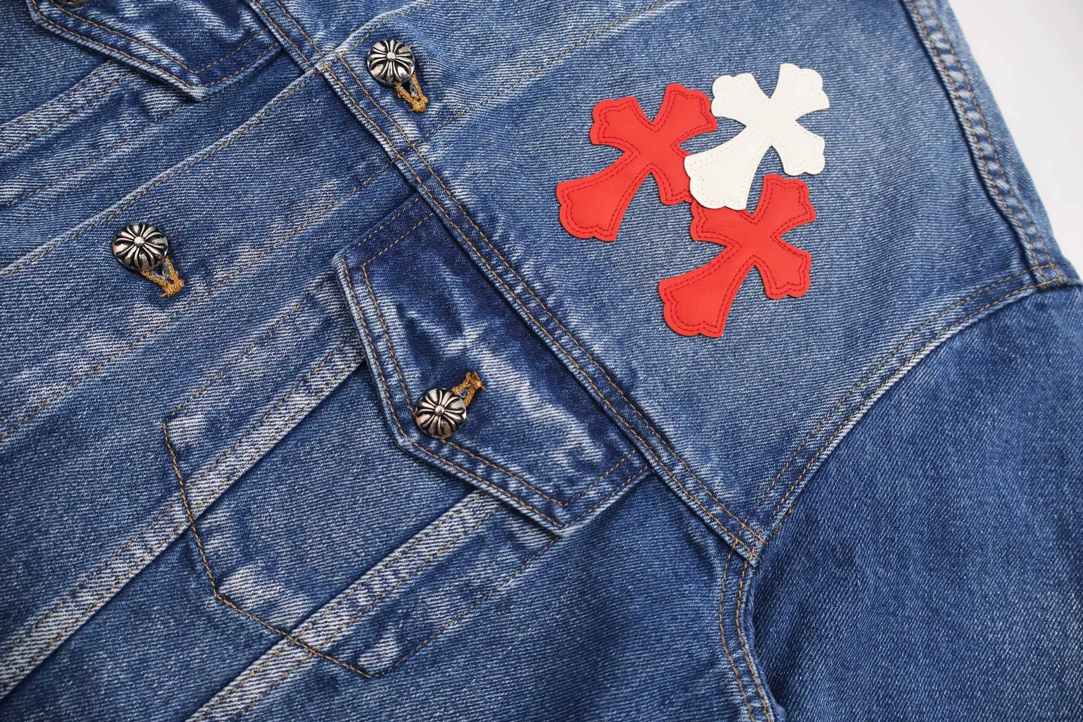 🅿️810 [Exclusive supply] CH Crow Heart Sleeve Cross-Flat Denim Jacket This denim jacket takes the brand's iconic cross element as its core, and stages a wonderful dialogue between hardcore aesthetics and street fashion on retro distressed denim fabric. Design details: the visual fantasy of Gothic symbols, the multi-dimensional expression of the cross totem: the red and white contrasting cross patches are staggered on the chest and back, making the brand more recognizable; the hollow cross pattern leather splicing on the sleeves combines the mystery of religious symbols with the punk-style deconstructed design. Every detail tells the dark aesthetics of Crowe's heart. Retro distressing with denim texture: Selected denim fabrics are treated with distressing techniques to show natural fading and texture, which not only retains the retro accent of denim items, but also adds a casual sense to the overall look. The ingenuity of hardware and tailoring: the metal buttons and hardware all have Croxin's iconic pattern, which shines with exquisite luster under the refraction of light; the neat tailoring of the classic denim jacket is suitable for a variety of wearing scenarios, and can create a strong personal style whether it is layered or worn alone. Croxin's denim jacket is not only a piece of clothing, but also a style badge that highlights unique aesthetics and rebellious attitude. For those who pursue individuality, they can leave their own hardcore mark in the fashion field. Size:S-M-L-XL